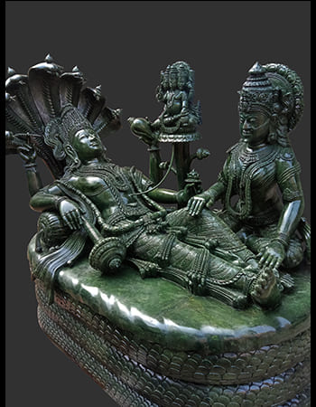 Masterfully crafted green stone religious idol with intricate jewelry and ceremonial attire