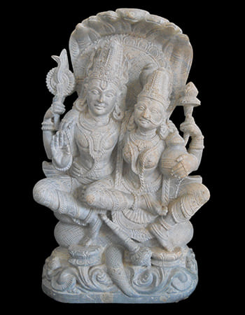 Delicate green stone carving of a dancing figure with elaborate headdress and flowing robes