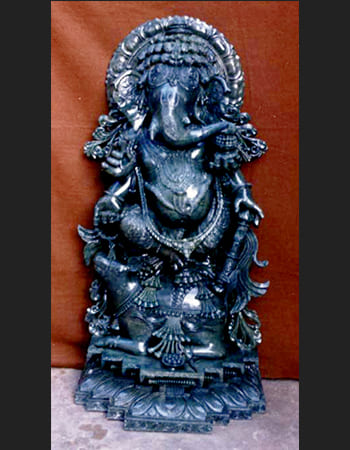 Sophisticated green stone sculpture of a seated deity with elaborate throne and divine attributes