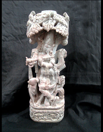 Elegant green stone sculpture of a dancing maiden with elaborate headdress and graceful pose