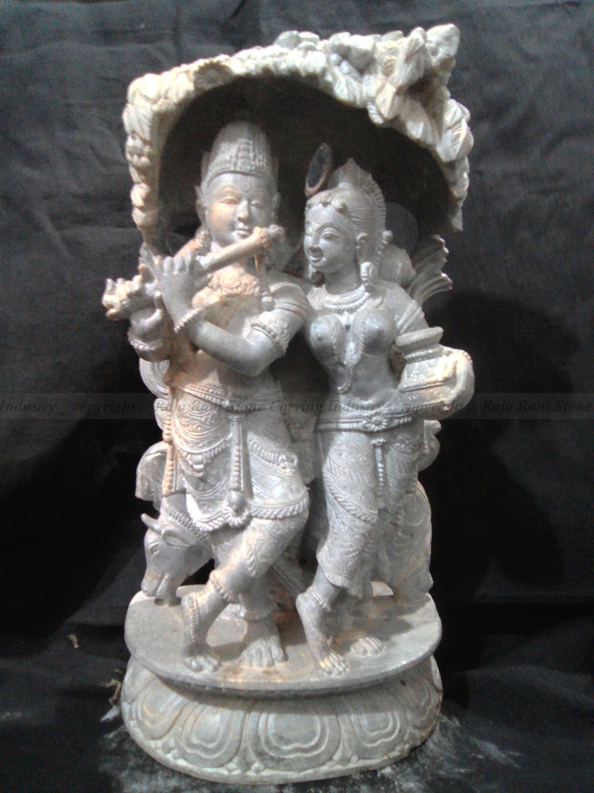 Sophisticated green stone sculpture of a royal figure with crown and ceremonial attire