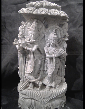 Artistic green stone carving of a musician playing traditional drums with cultural significance