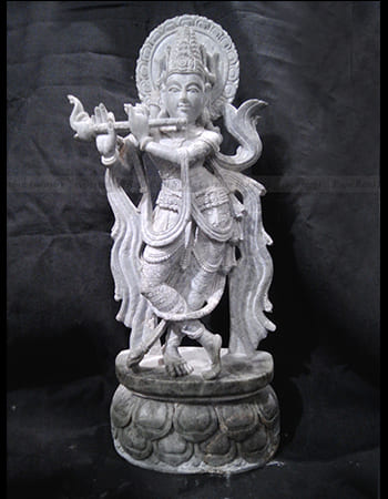 Beautiful green stone sculpture featuring a devotional scene with multiple figures in worship