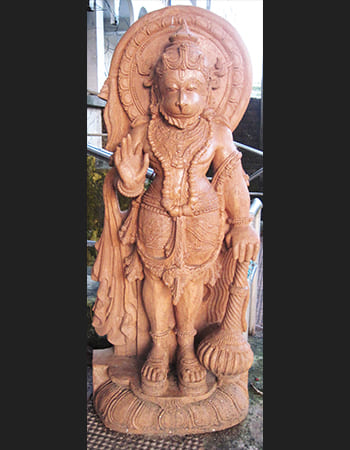 Majestic Hanuman sculpture with blessing gesture in natural sandstone, embodying divine protection and spiritual energy