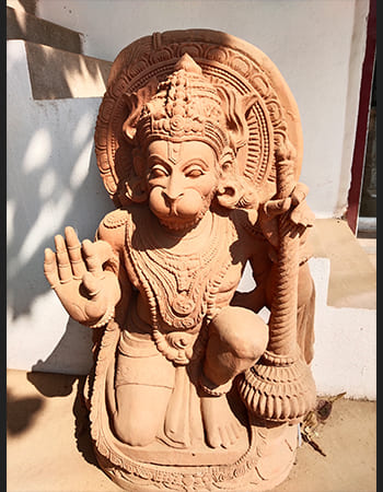Traditional Lord Hanuman statue in sandstone with detailed carving, representing fearless devotion and sacred strength
