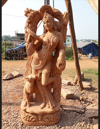 Sandstone Devadasi sculpture showcasing graceful dance movement with ornate clothing details