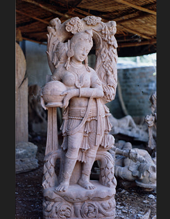 Classical dancing lady statue with intricate hair styling and traditional jewelry in sandstone