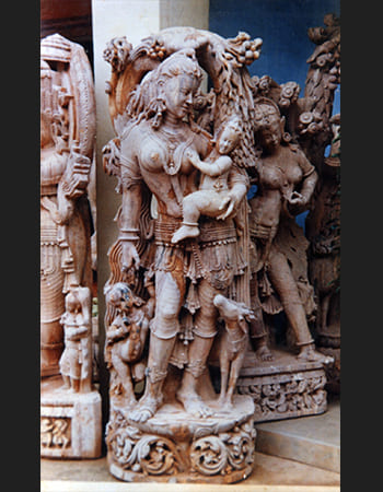 Traditional Devadasi sculpture in dynamic dance pose with detailed fabric carving