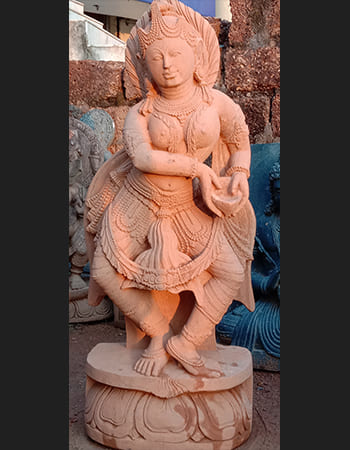 Traditional dancing lady statue with flowing garments and intricate jewelry details in sandstone