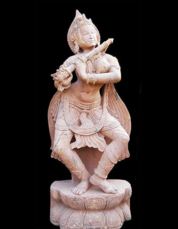 Elegant Devadasi statue in sandstone showcasing divine feminine grace with intricate traditional details