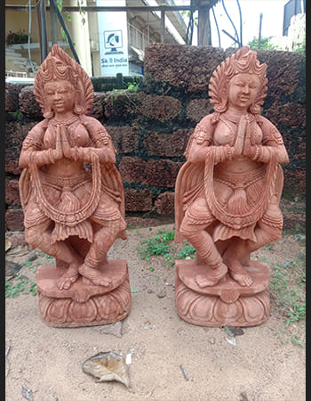 Intricately carved Devadasi sculpture with traditional costume and jewelry details in sandstone