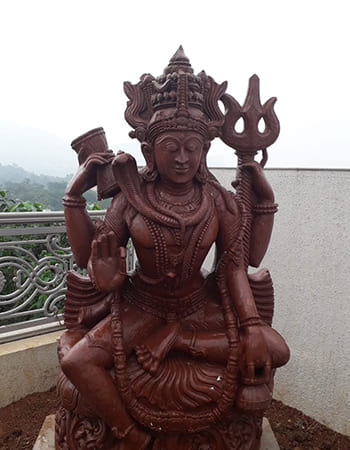 Shiva Lingam with sacred serpent coiled around, traditional sandstone carving representing divine energy and fertility